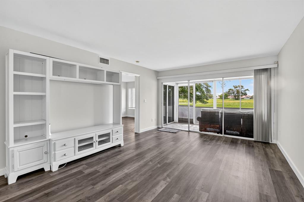 260 Northwest 67th Street, Unit A104 Boca Raton, FL 33487 - Photo 11 of 43 a view of a livingroom with furniture wooden floor and window