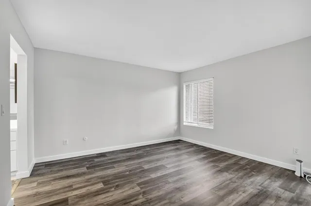 a view of a room that has wooden floor and window in it