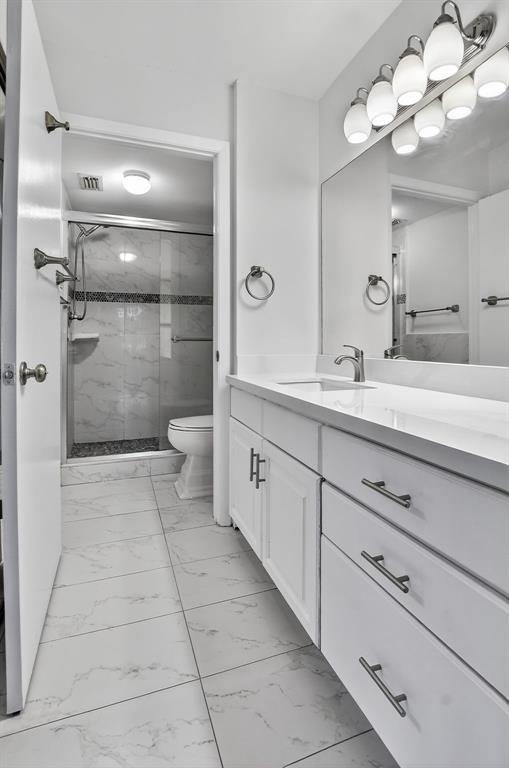 260 Northwest 67th Street, Unit A104 Boca Raton, FL 33487 - Photo 18 of 43 a spacious bathroom with a granite countertop sink a toilet and a mirror