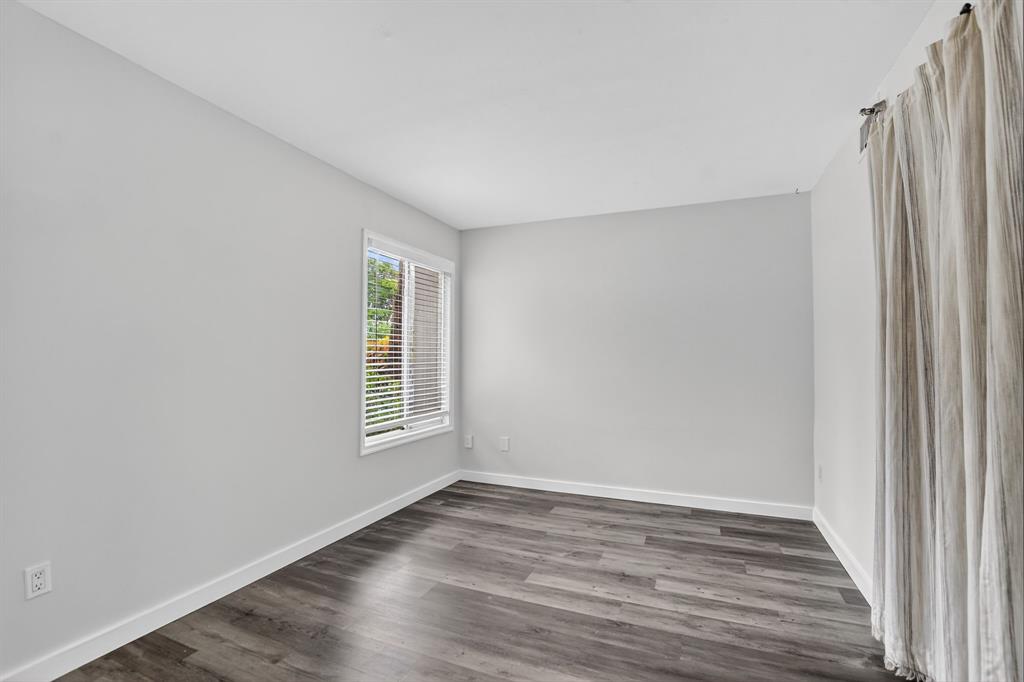 260 Northwest 67th Street, Unit A104 Boca Raton, FL 33487 - Photo 21 of 43 a view of an empty room with wooden floor and a window