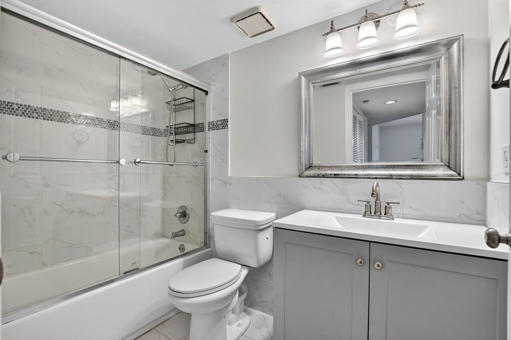 260 Northwest 67th Street, Unit A104 Boca Raton, FL 33487 - Photo 23 of 43 a bathroom with a toilet sink and shower