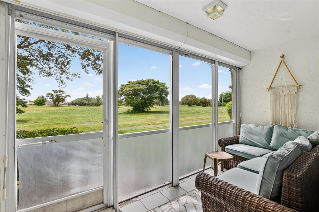 260 Northwest 67th Street, Unit A104 Boca Raton, FL 33487 - Photo 27 of 43 a living room with couch and a floor to ceiling window