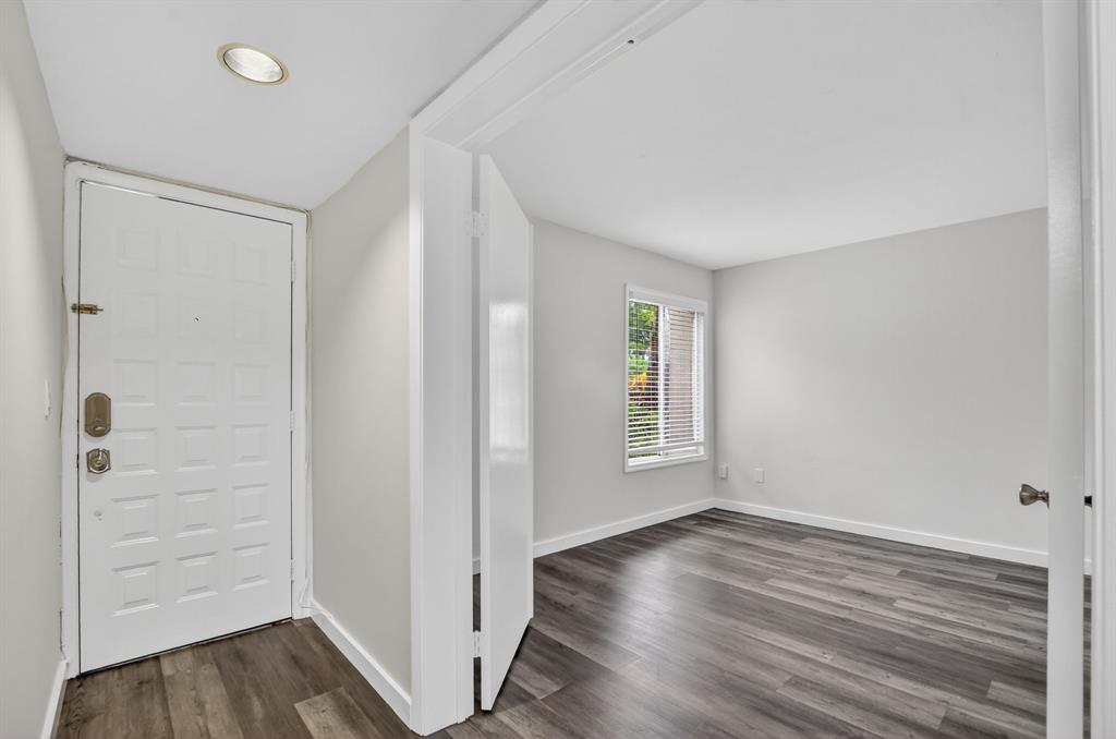 260 Northwest 67th Street, Unit A104 Boca Raton, FL 33487 - Photo 3 of 43 an empty room with wooden floor and windows