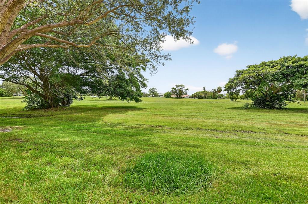 260 Northwest 67th Street, Unit A104 Boca Raton, FL 33487 - Photo 31 of 43 a view of a grassy field with trees