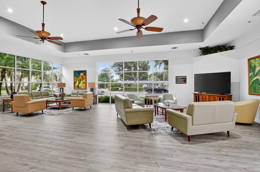 260 Northwest 67th Street, Unit A104 Boca Raton, FL 33487 - Photo 35 of 43 a living room with furniture flat screen tv and a large window