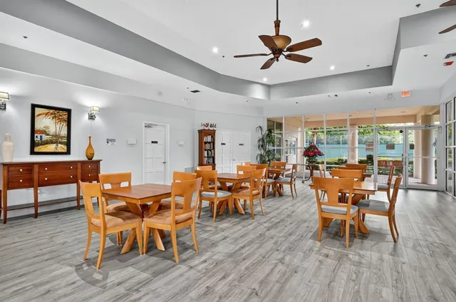a dining room with furniture a floor to ceiling window and wooden floor
