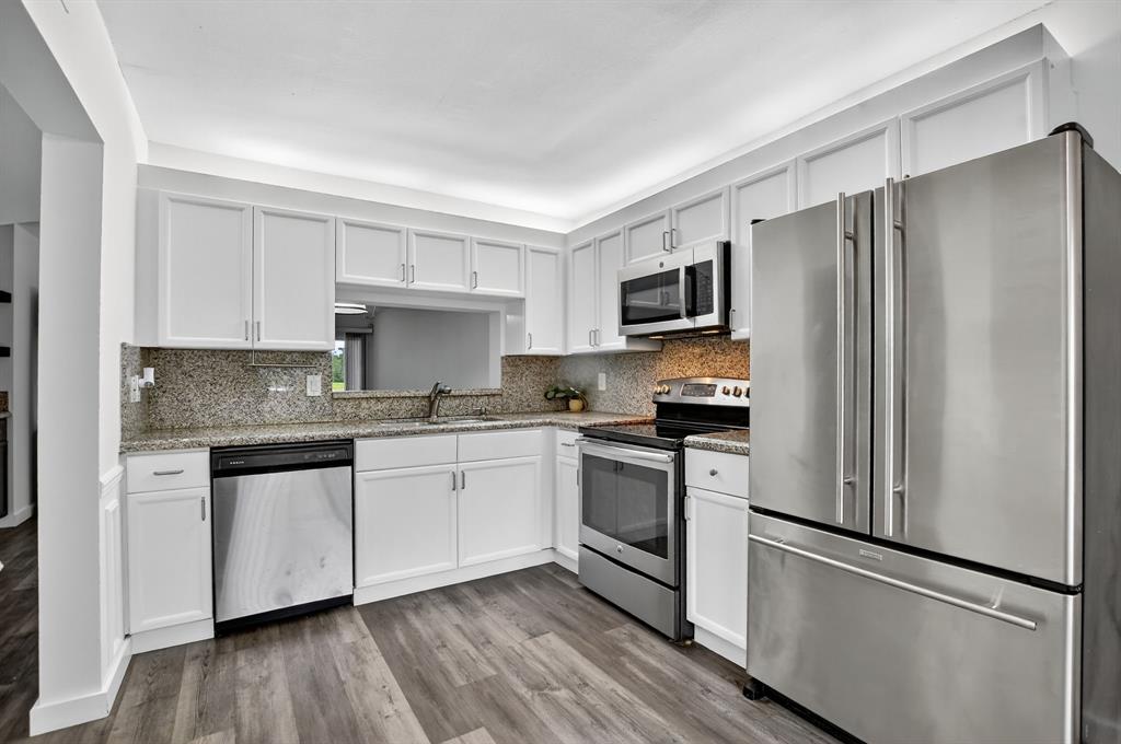 260 Northwest 67th Street, Unit A104 Boca Raton, FL 33487 - Photo 4 of 43 a kitchen with granite countertop stainless steel appliances a refrigerator a stove top oven a sink and dishwasher