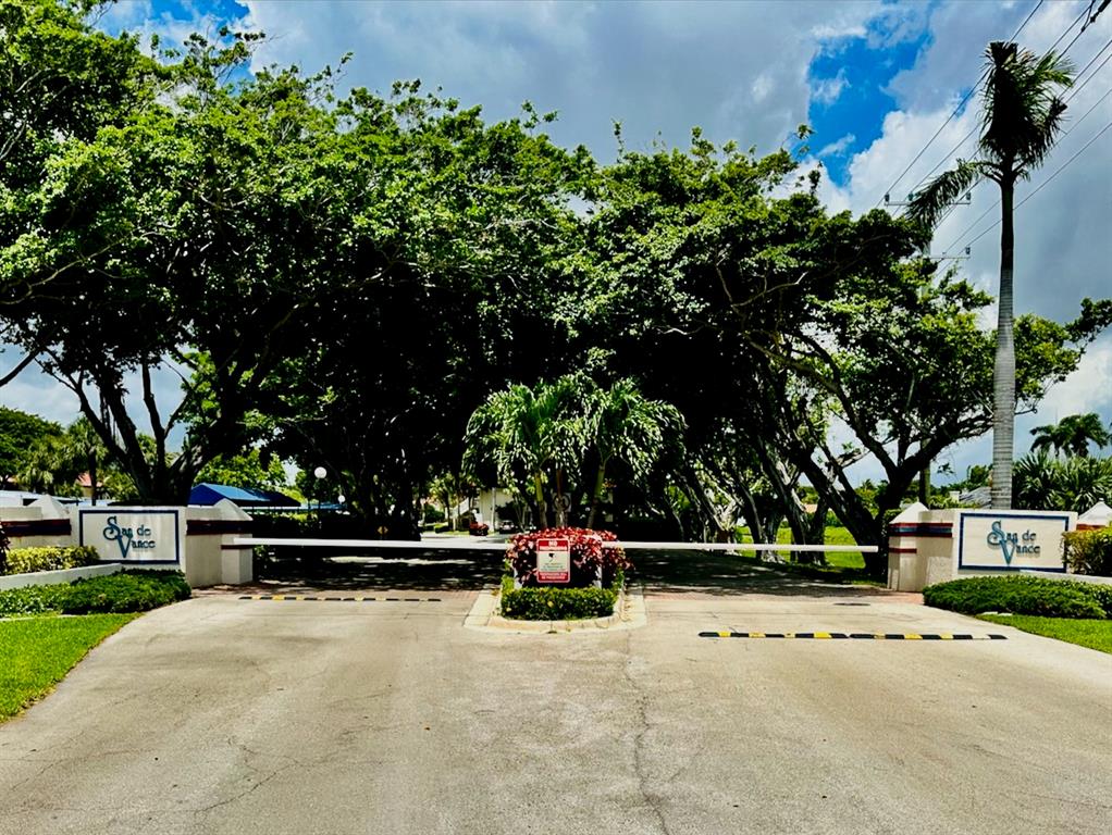 260 Northwest 67th Street, Unit A104 Boca Raton, FL 33487 - Photo 43 of 43 a view of a yard with table and chairs potted plants and large trees