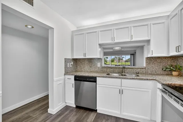 a kitchen with granite countertop white cabinets and a sink