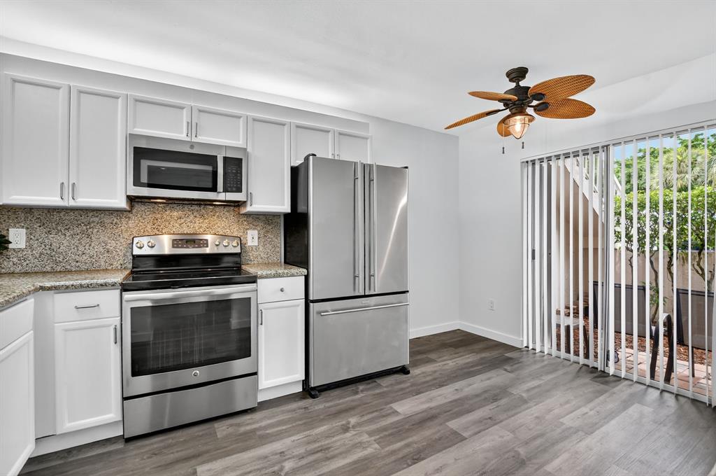 260 Northwest 67th Street, Unit A104 Boca Raton, FL 33487 - Photo 6 of 43 a kitchen with stainless steel appliances a refrigerator stove and microwave