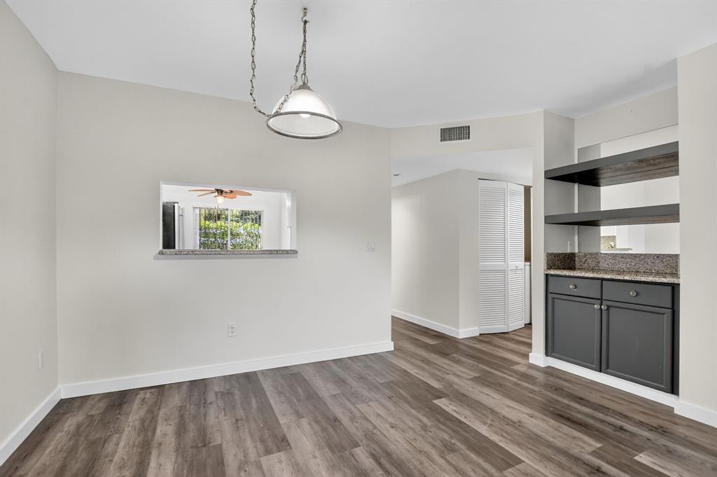 260 Northwest 67th Street, Unit A104 Boca Raton, FL 33487 - Photo 9 of 43 a view of a kitchen with a refrigerator cabinets and wooden floor