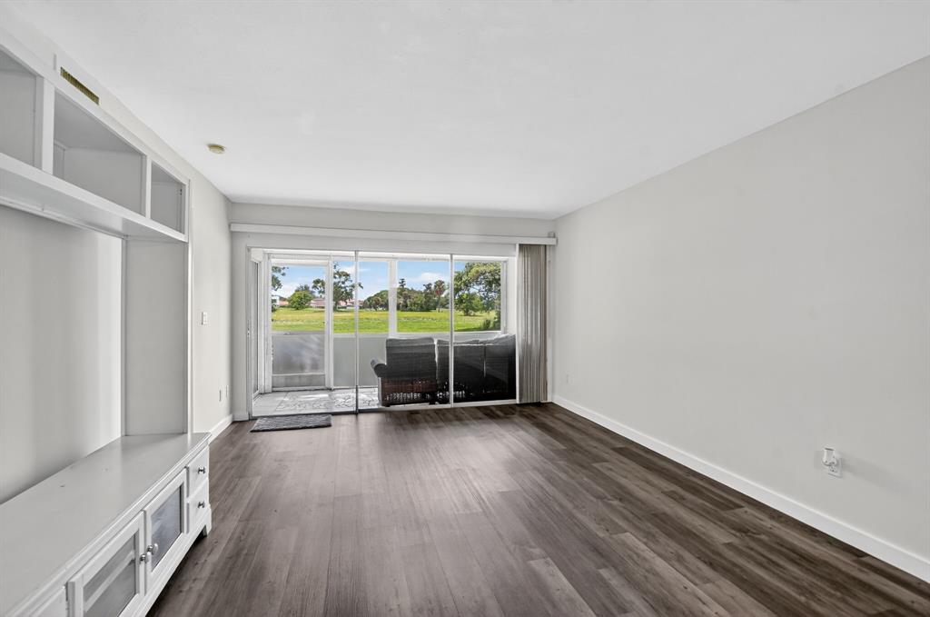 260 Northwest 67th Street, Unit A104 Boca Raton, FL 33487 - Photo 10 of 43 wooden floor in an empty room with a window
