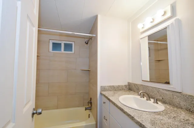 a bathroom with a granite countertop sink and a mirror