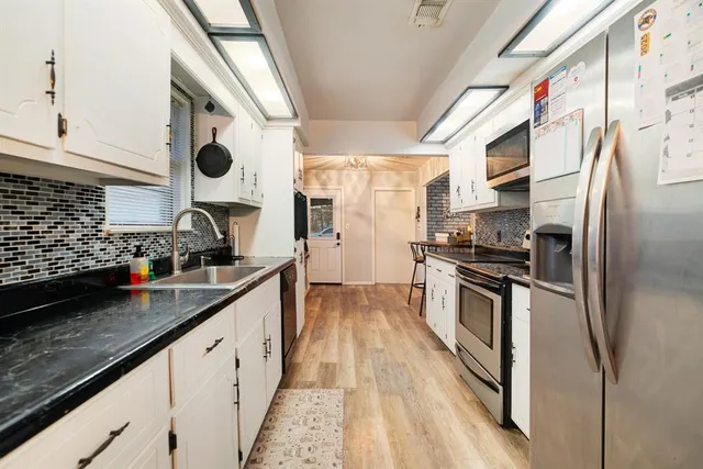 a kitchen with stainless steel appliances granite countertop a sink and a stove