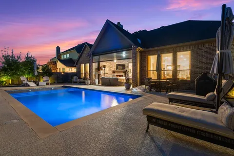 a view of swimming pool with seating area and barbeque oven