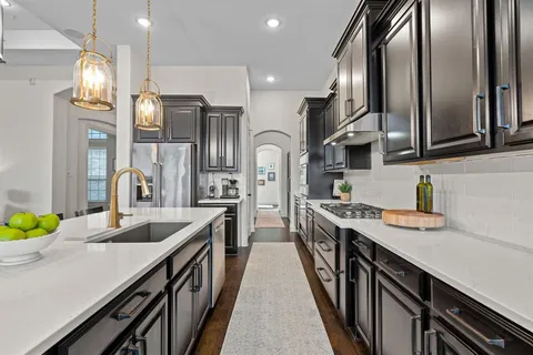 a kitchen with stainless steel appliances granite countertop lots of counter top space a sink refrigerator and cabinets