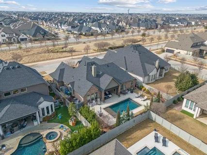 an aerial view of residential houses with outdoor space and ocean view