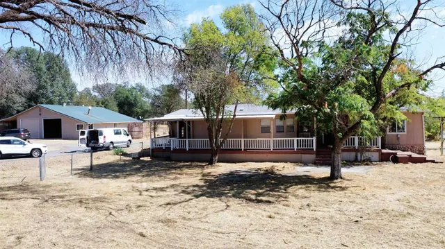 a tree in front of a white house