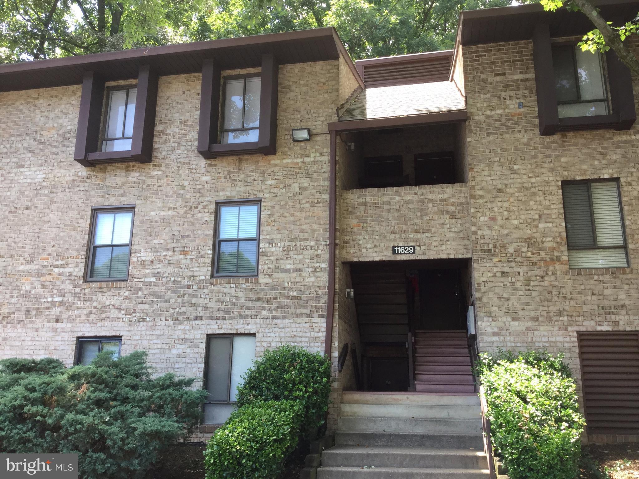 11629 Stoneview Square, Unit 21C Reston, VA 20191 - Photo 1 of 30 a front view of a house with a garden