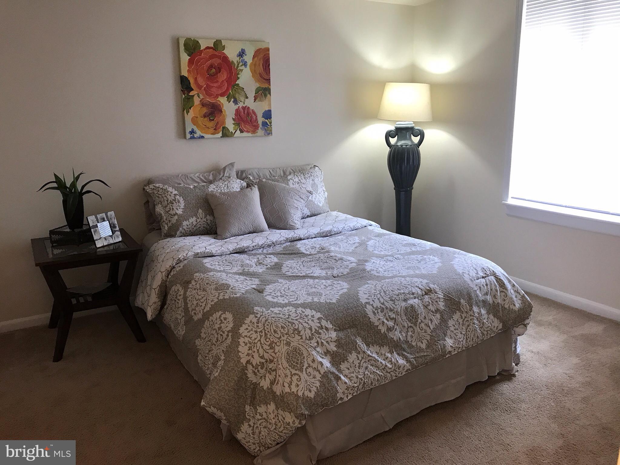 11629 Stoneview Square, Unit 21C Reston, VA 20191 - Photo 14 of 30 a bed sitting in a bedroom next to a window