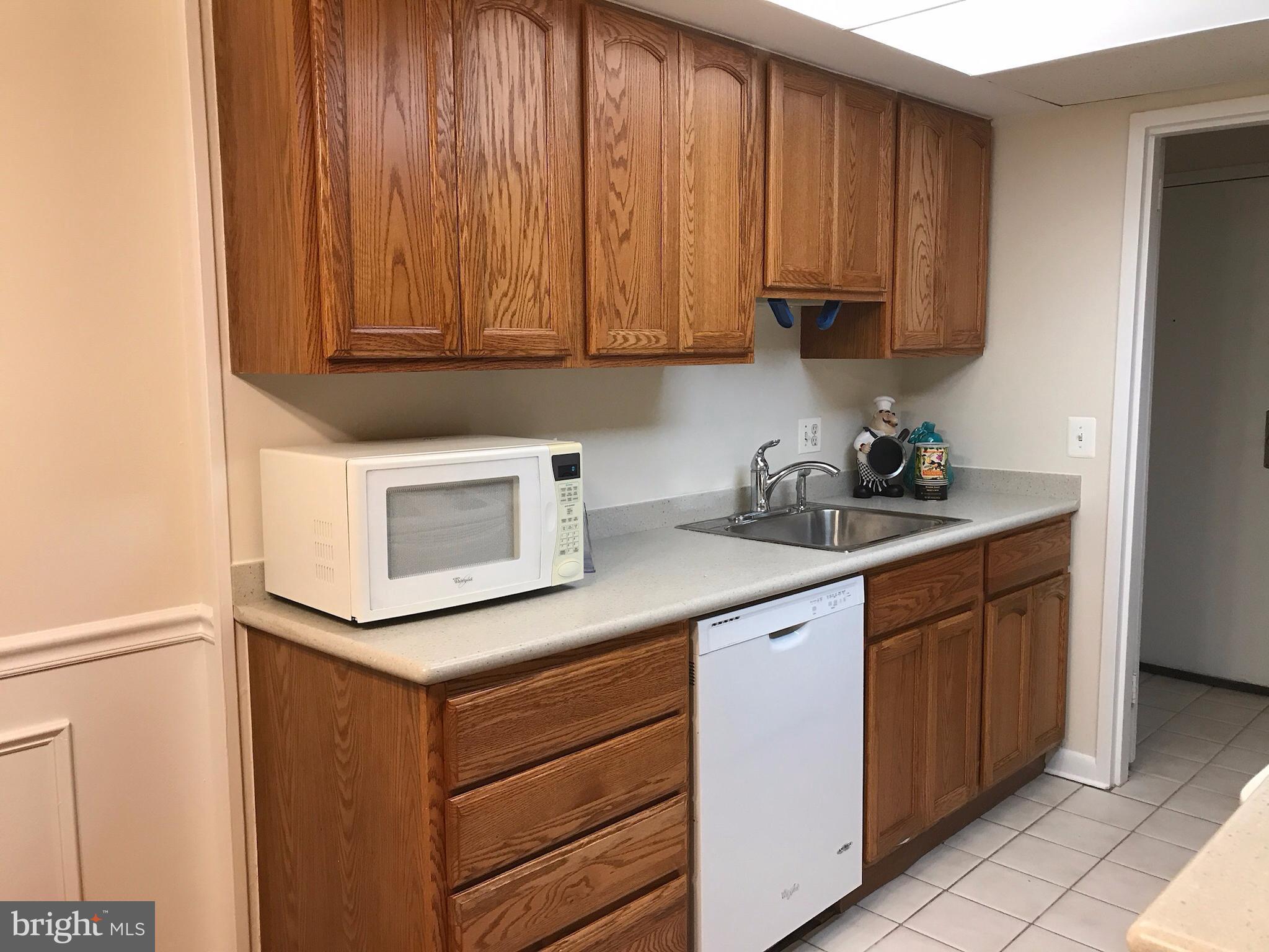 11629 Stoneview Square, Unit 21C Reston, VA 20191 - Photo 3 of 30 a kitchen with stainless steel appliances granite countertop wooden cabinets and a stove top oven