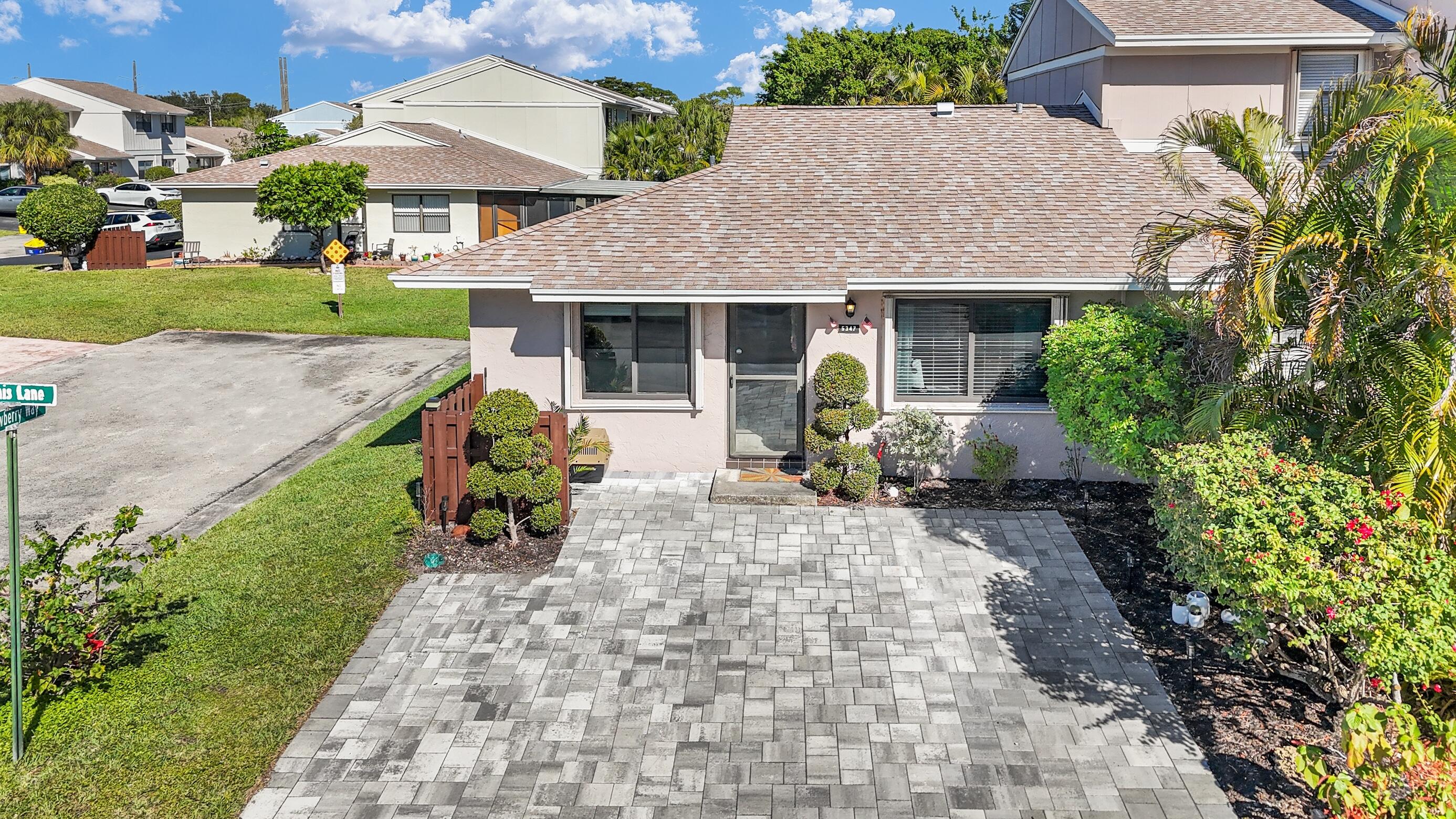 5347 Tennis Lane, Unit 5347 Delray Beach, FL 33484 - Photo 1 of 41 a front view of a house with garden