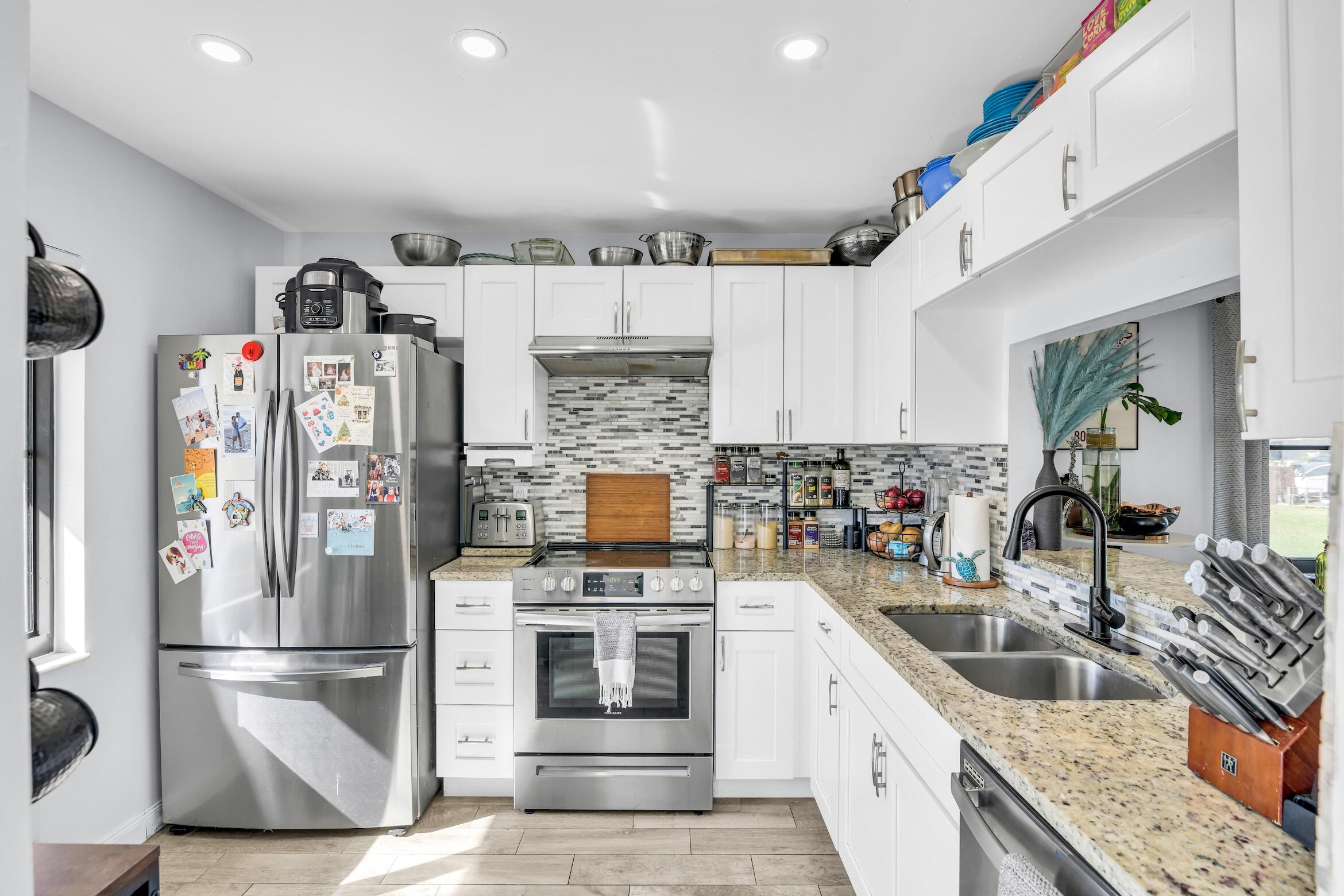5347 Tennis Lane, Unit 5347 Delray Beach, FL 33484 - Photo 11 of 41 a kitchen with granite countertop a refrigerator and a sink