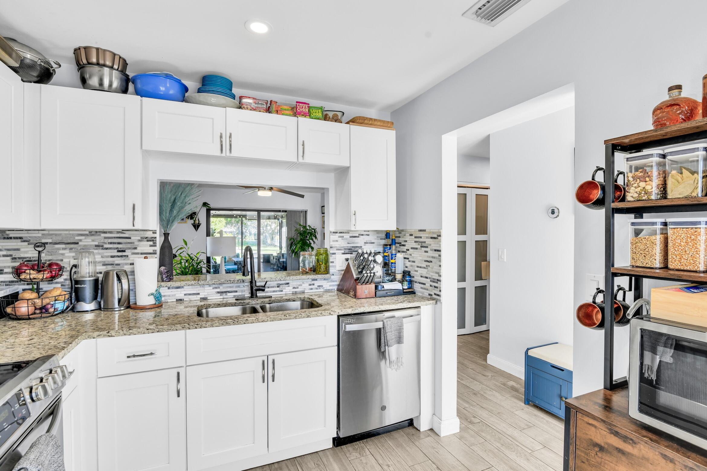 5347 Tennis Lane, Unit 5347 Delray Beach, FL 33484 - Photo 14 of 41 a kitchen with white cabinets and sink