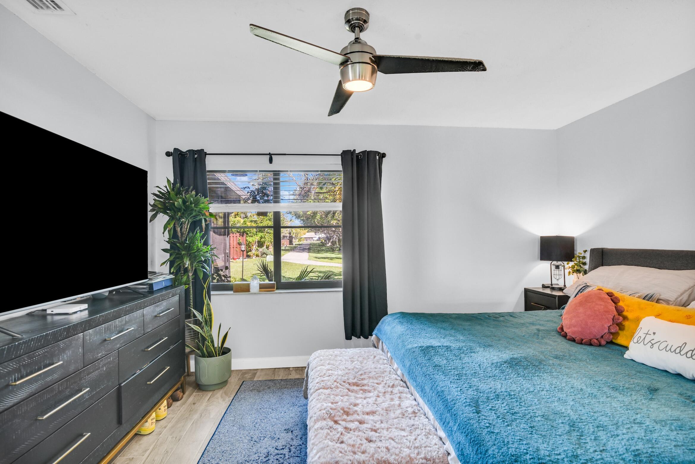 5347 Tennis Lane, Unit 5347 Delray Beach, FL 33484 - Photo 17 of 41 a bedroom with bed and flat screen tv