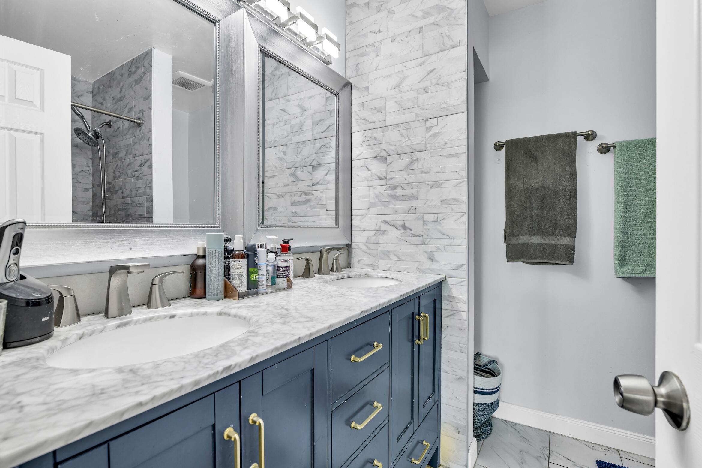 5347 Tennis Lane, Unit 5347 Delray Beach, FL 33484 - Photo 19 of 41 a bathroom with a granite countertop sink a toilet and mirror