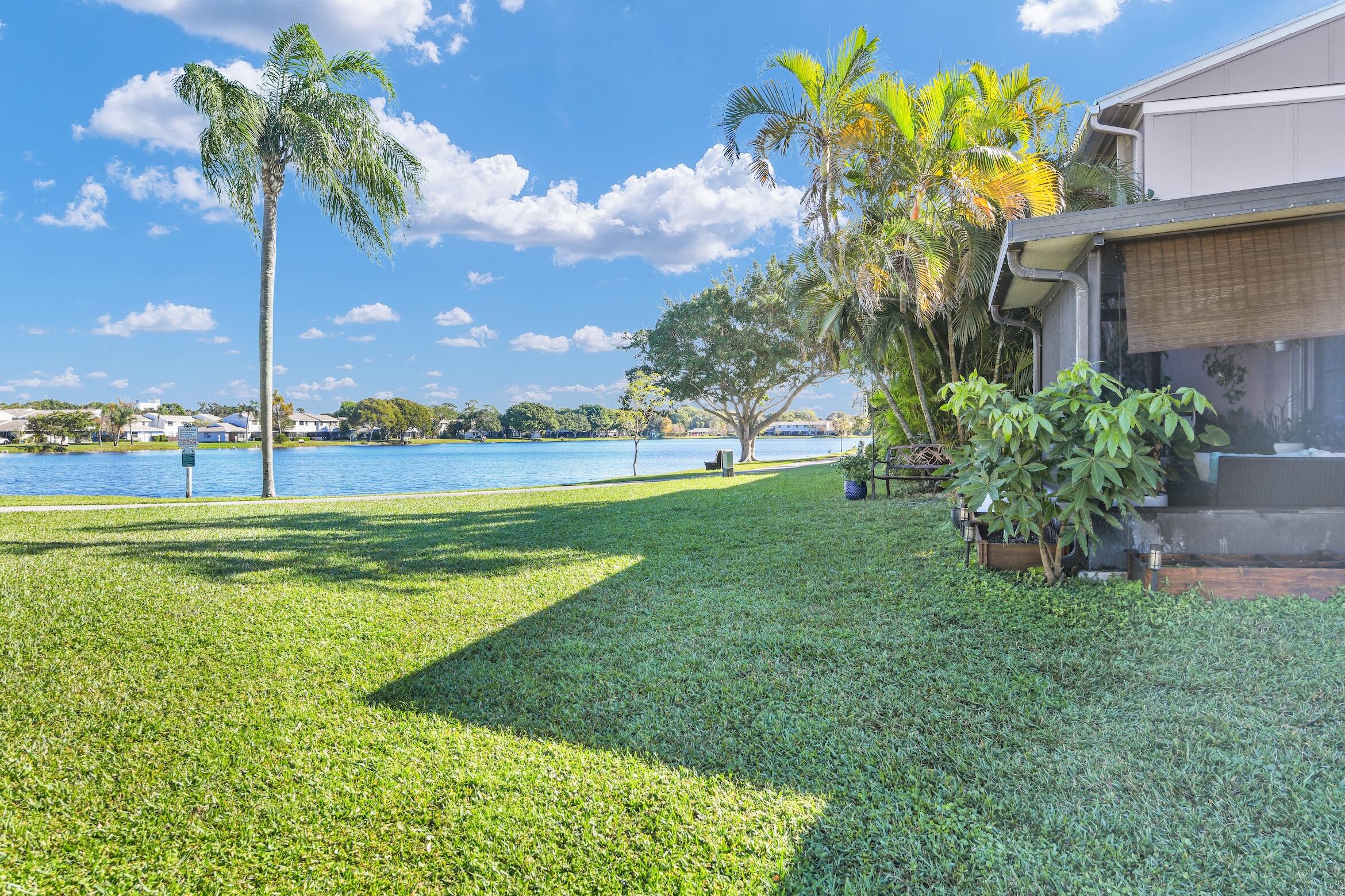 5347 Tennis Lane, Unit 5347 Delray Beach, FL 33484 - Photo 30 of 41 a view of a house with a big yard and palm trees