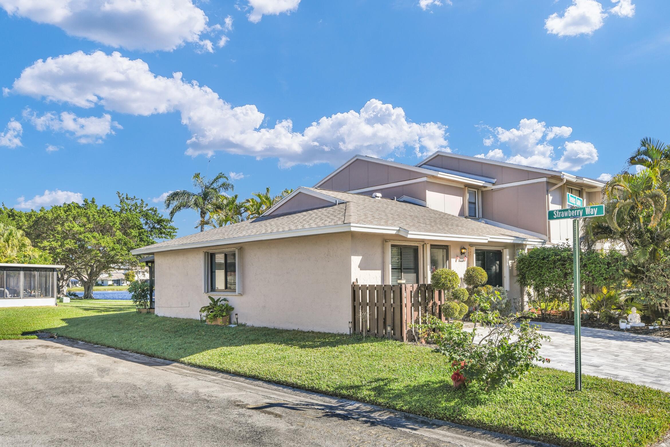 5347 Tennis Lane, Unit 5347 Delray Beach, FL 33484 - Photo 3 of 41 a front view of a house with a garden