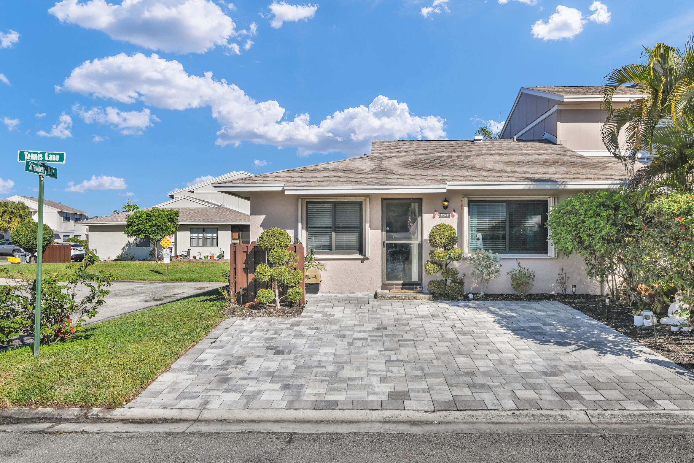 5347 Tennis Lane, Unit 5347 Delray Beach, FL 33484 - Photo 4 of 41 a front view of a house with garden and patio