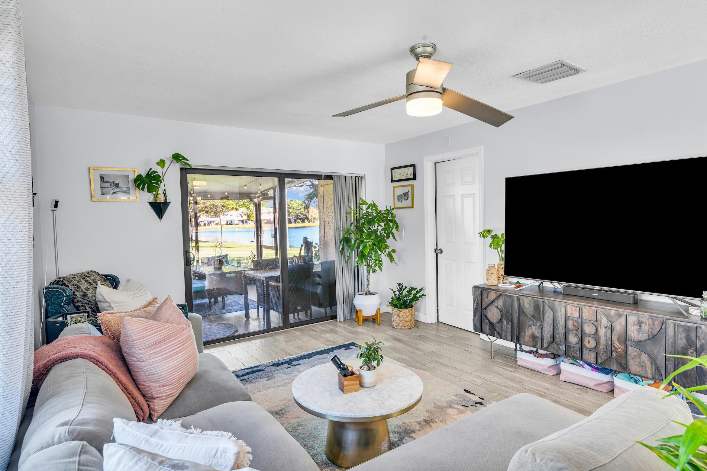 5347 Tennis Lane, Unit 5347 Delray Beach, FL 33484 - Photo 7 of 41 a living room with furniture and a flat screen tv