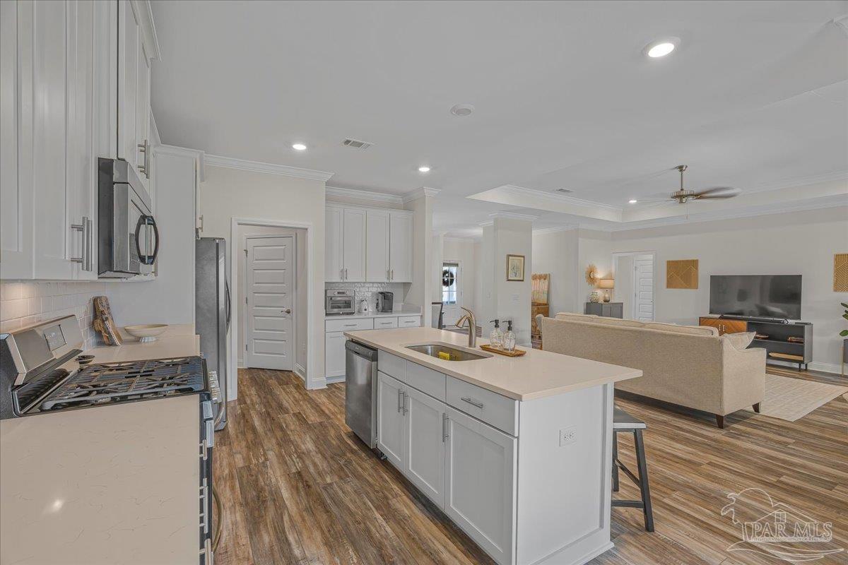 441 Broadleaf Circle Cantonment, FL 32533 - Photo 13 of 42 a large kitchen with stainless steel appliances granite countertop a lot of counter space and wooden floors