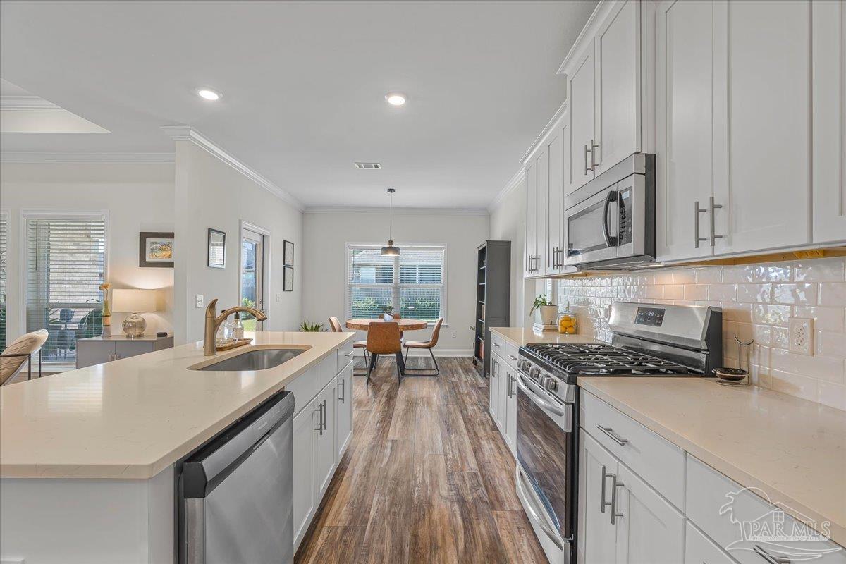 441 Broadleaf Circle Cantonment, FL 32533 - Photo 15 of 42 a kitchen with granite countertop a sink stove and cabinets