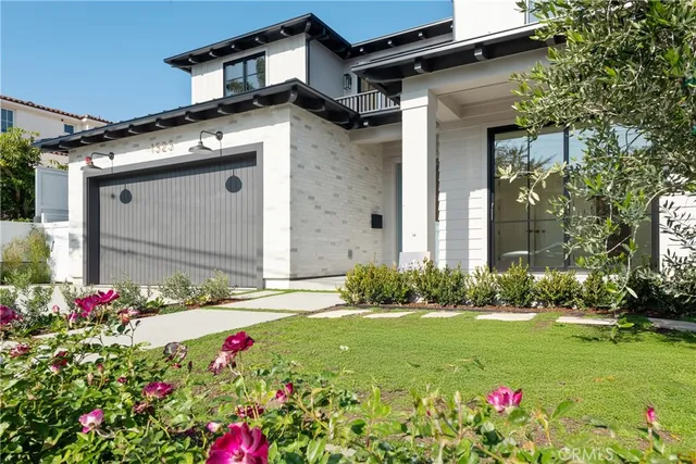 a flower garden is sitting in front of a house