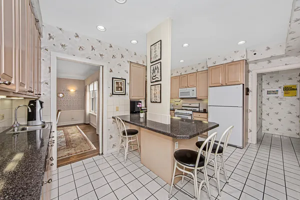 a kitchen with granite countertop a sink and a refrigerator