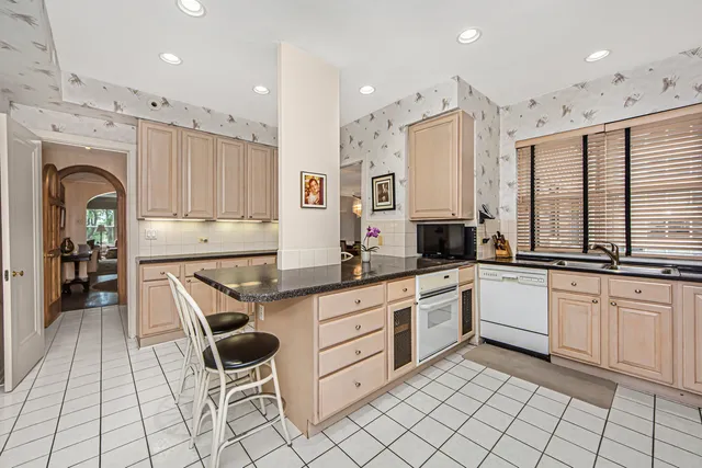 a kitchen with stainless steel appliances kitchen island granite countertop a sink and cabinets