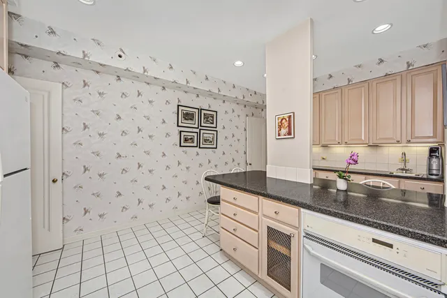 a kitchen with granite countertop white cabinets and stainless steel appliances