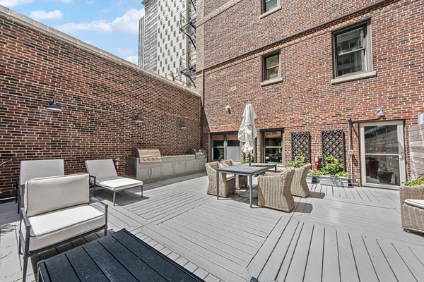 a view of a roof deck with couches and wooden floor