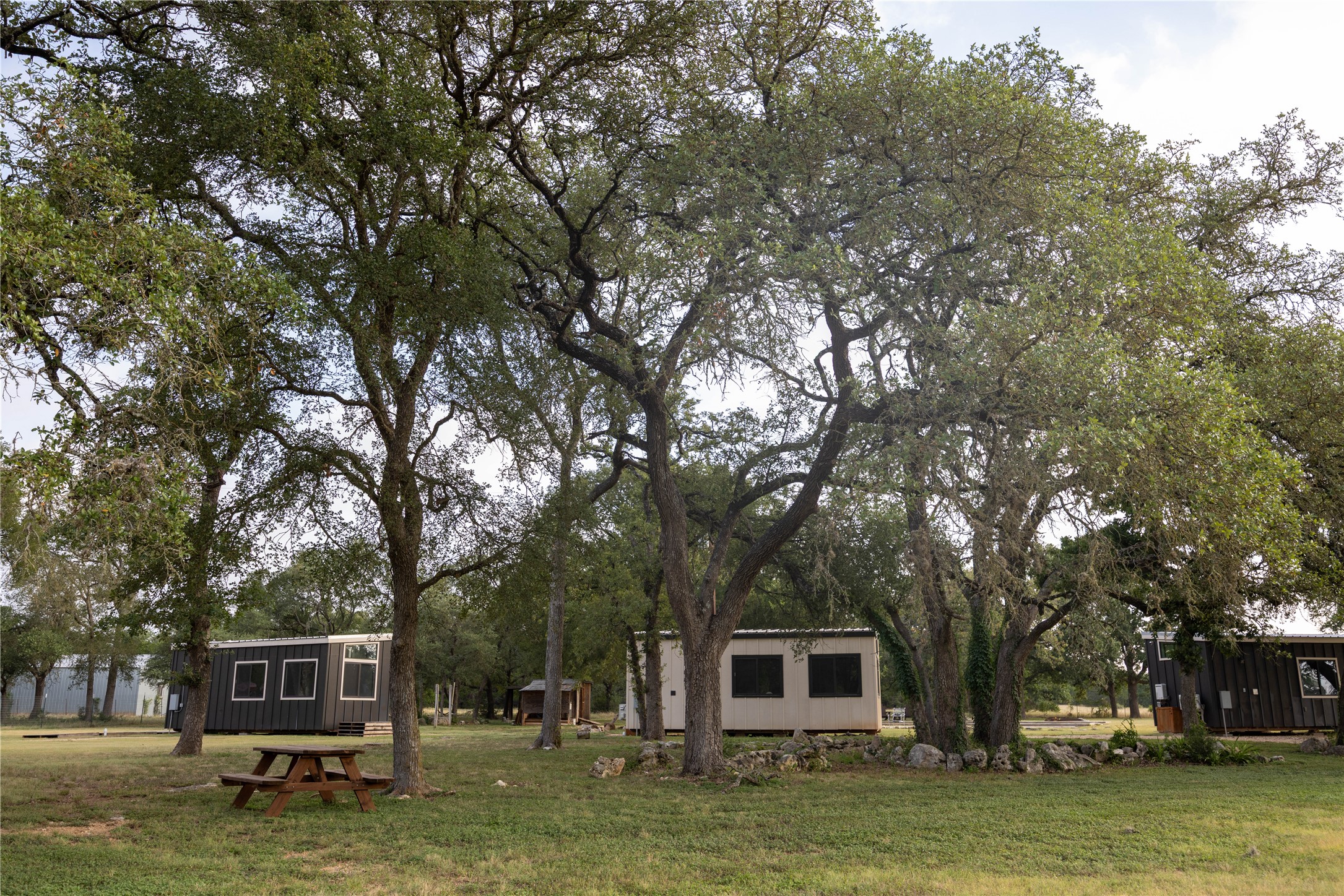 240 Lanier Ranch Road, Unit B Driftwood, TX 78619 - Photo 9 of 26 Scattered among mature trees, a collection of charming structures creates a private, idyllic retreat.