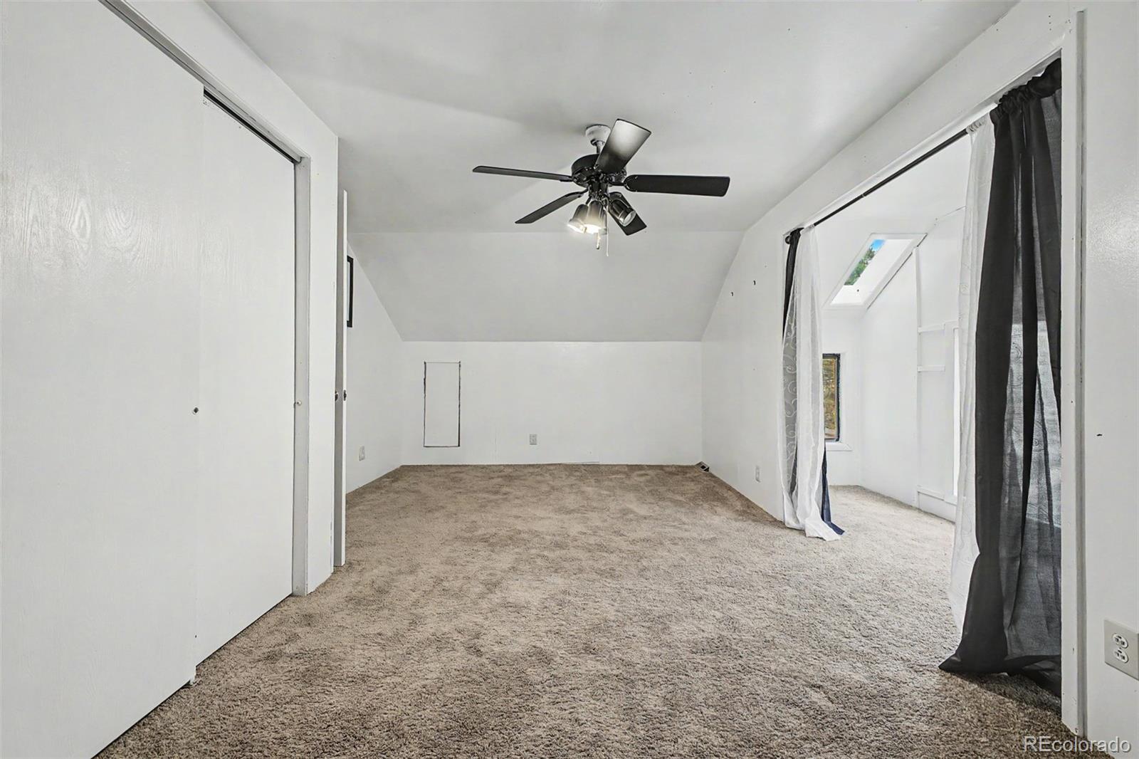 145 Bailey Drive Bailey, CO 80421 - Photo 13 of 31 an empty room with a ceiling fan and glass door