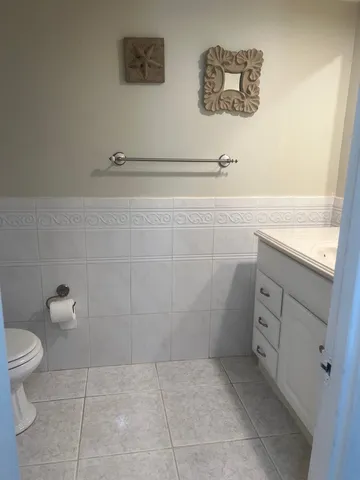 a bathroom with a granite countertop sink a toilet and a mirror