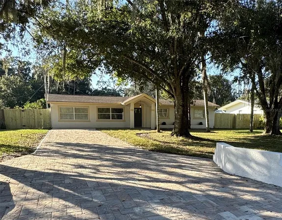 a view of a house with a yard and large tree