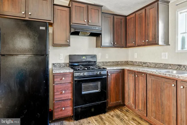a kitchen with granite countertop wooden cabinets and stainless steel appliances