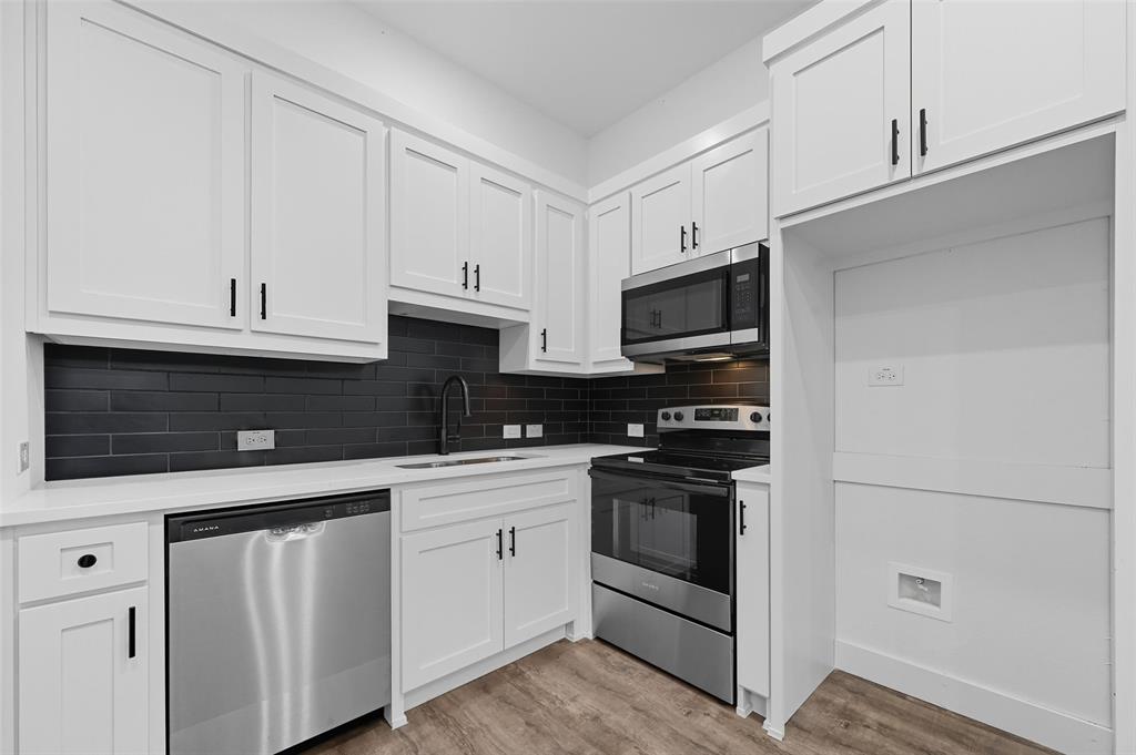1315 Oneal Street, Unit B Commerce, TX 75428 - Photo 3 of 14 a kitchen with white cabinets and stainless steel appliances