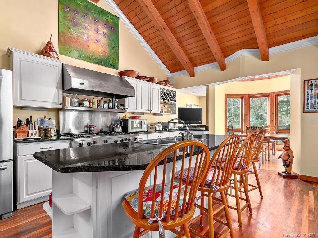 950 Walker Road Waynesville, NC 28786 - Photo 11 of 29 a kitchen with a table chairs stove and wooden floor