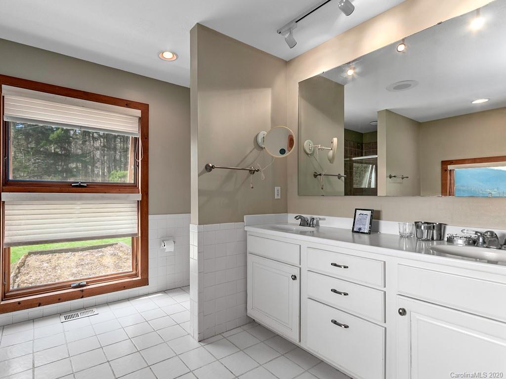 950 Walker Road Waynesville, NC 28786 - Photo 14 of 29 a bathroom with a granite countertop sink mirror and window