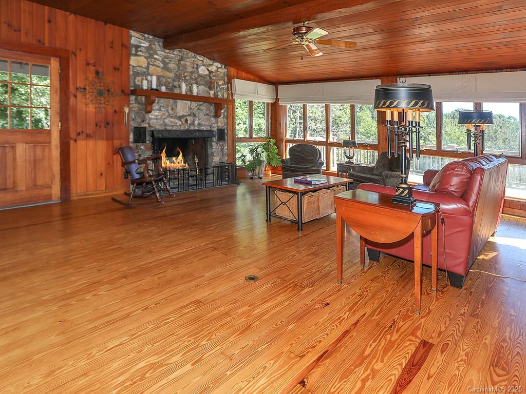 950 Walker Road Waynesville, NC 28786 - Photo 7 of 29 a living room with furniture a fireplace and floor to ceiling windows